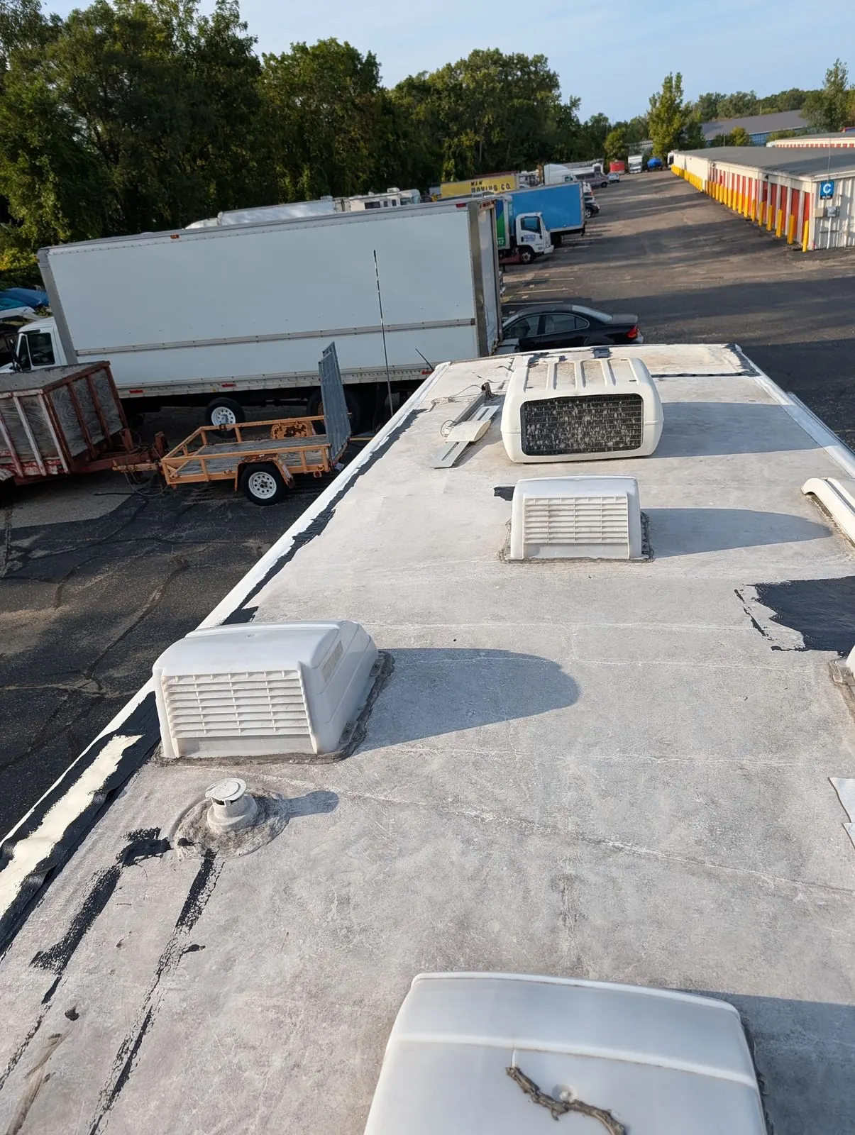 RV roof showing the air conditioner, vent covers, and sealant seams during an inspection