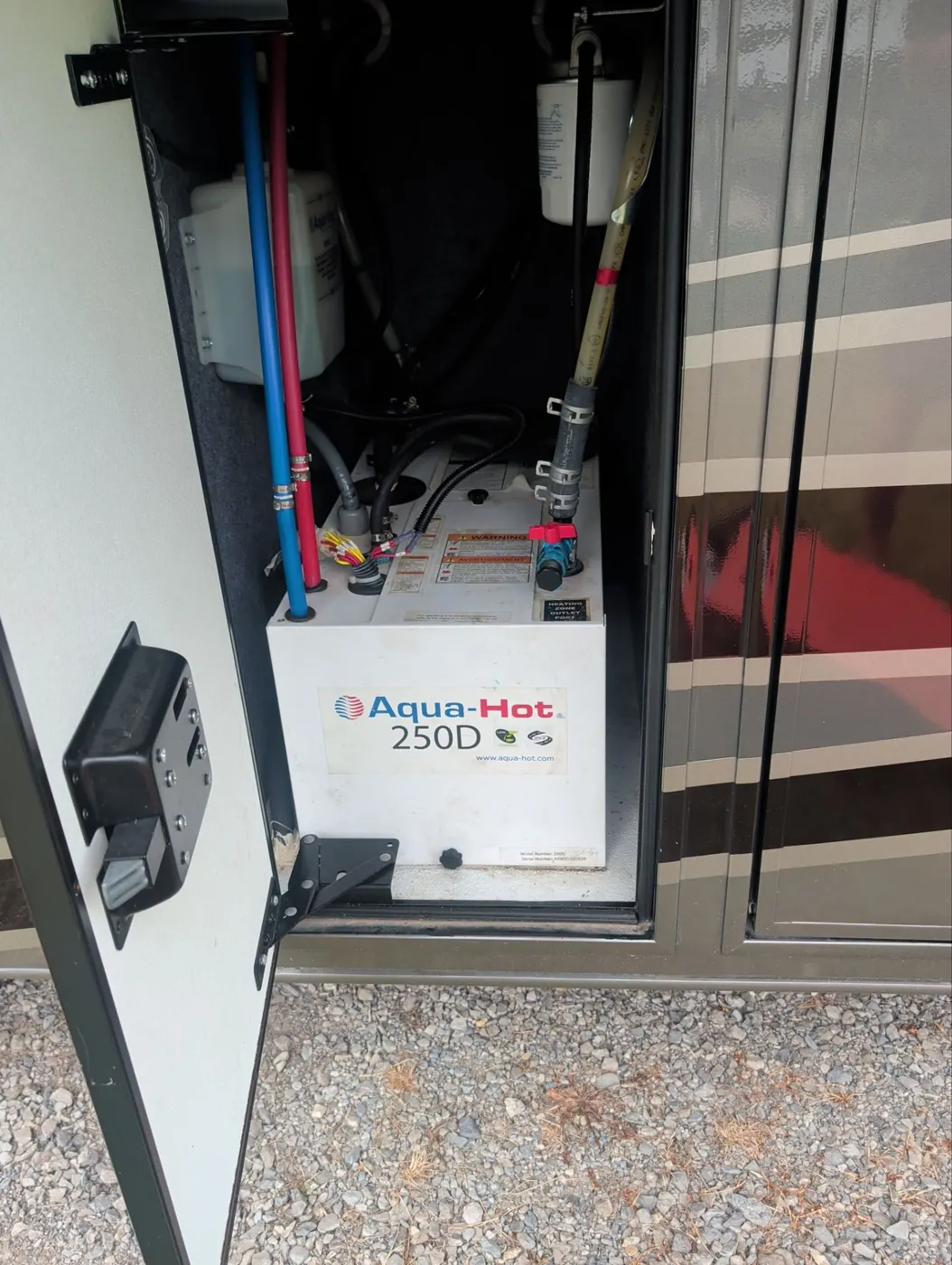 Aqua-Hot 250D unit installed in an exterior motorhome bay with the access door open