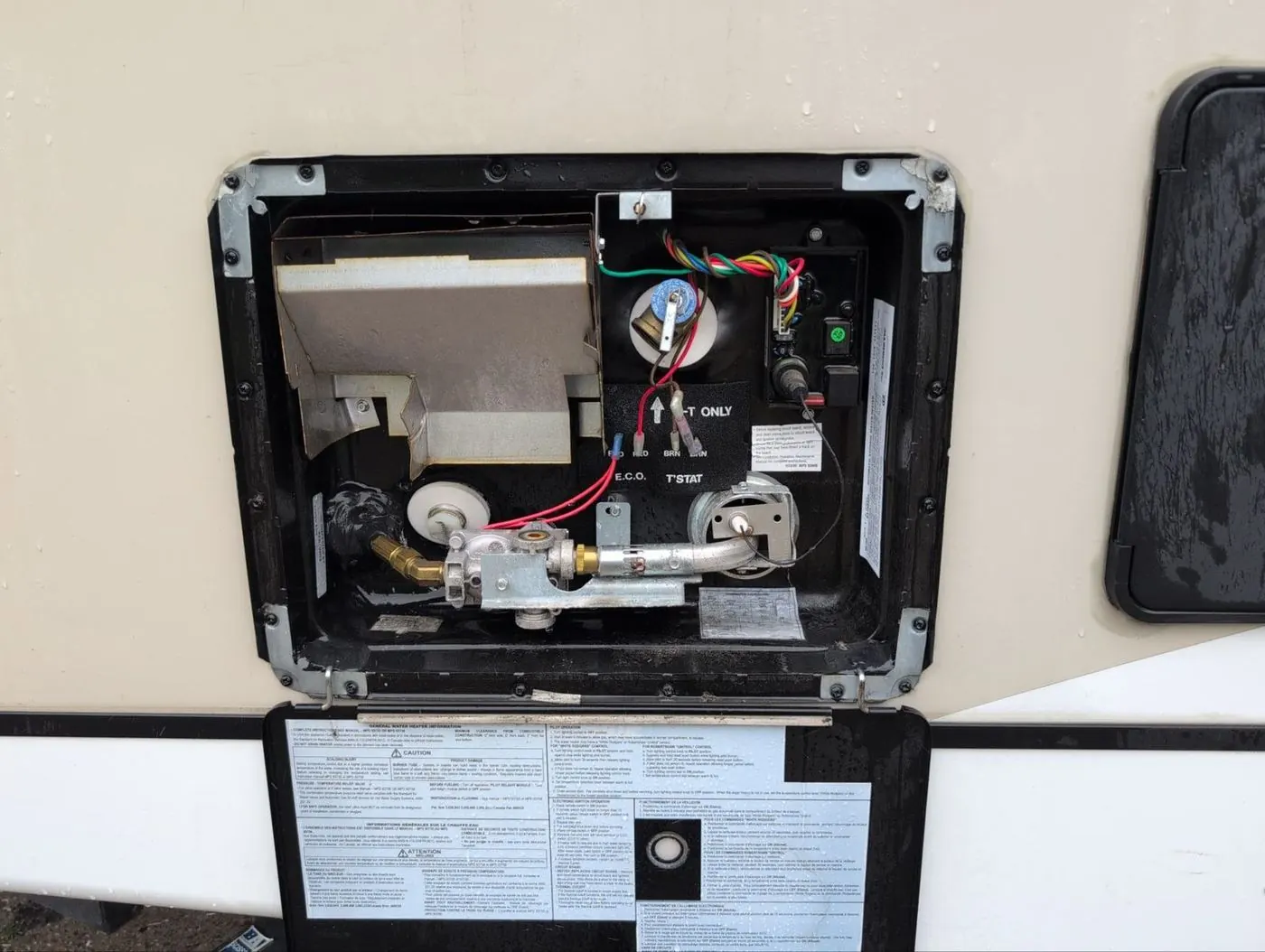 RV water heater burner, gas valve, and thermostat reached through the exterior access panel
