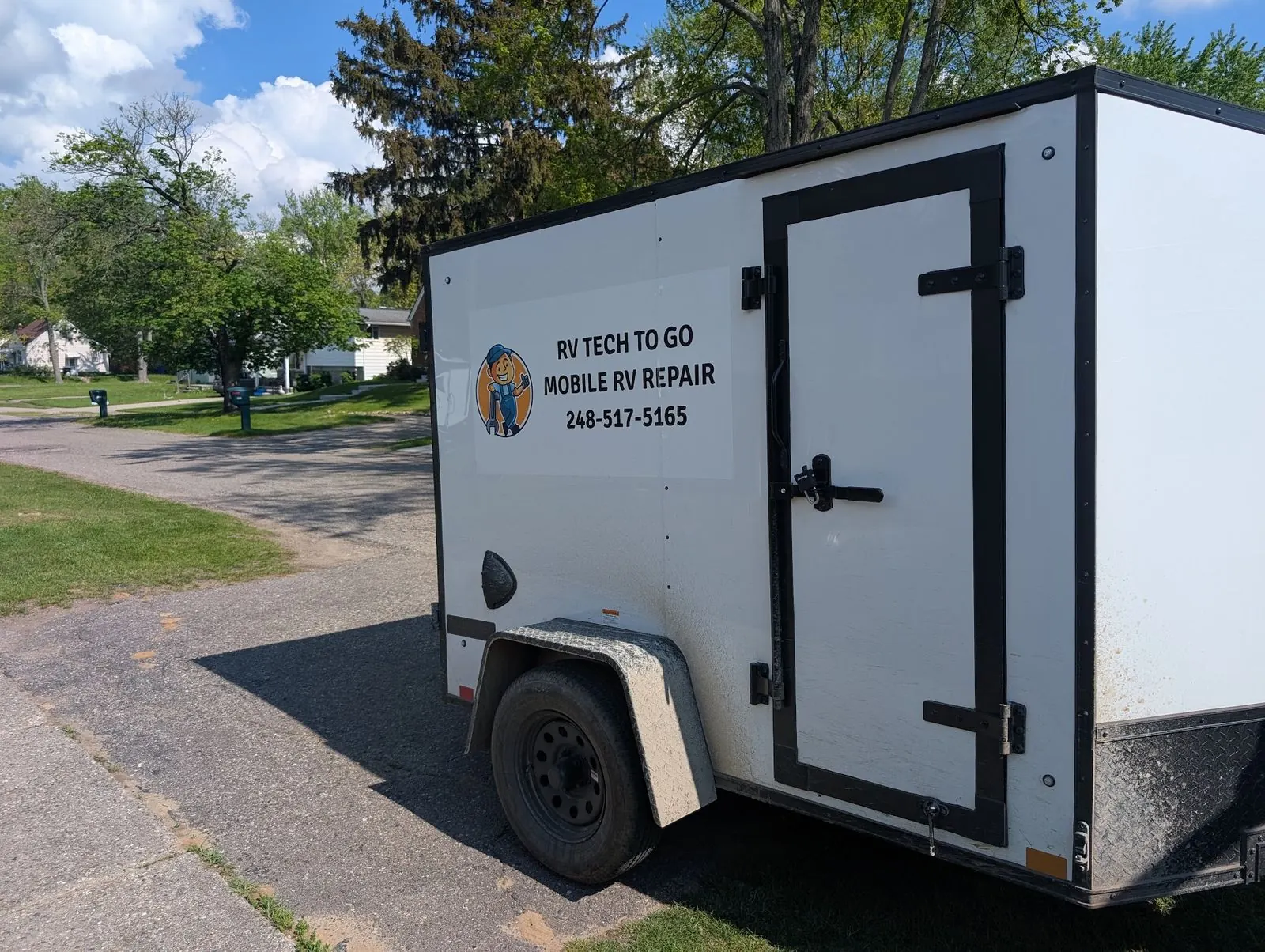 Enclosed RV Tech To Go mobile RV repair trailer parked in a residential driveway