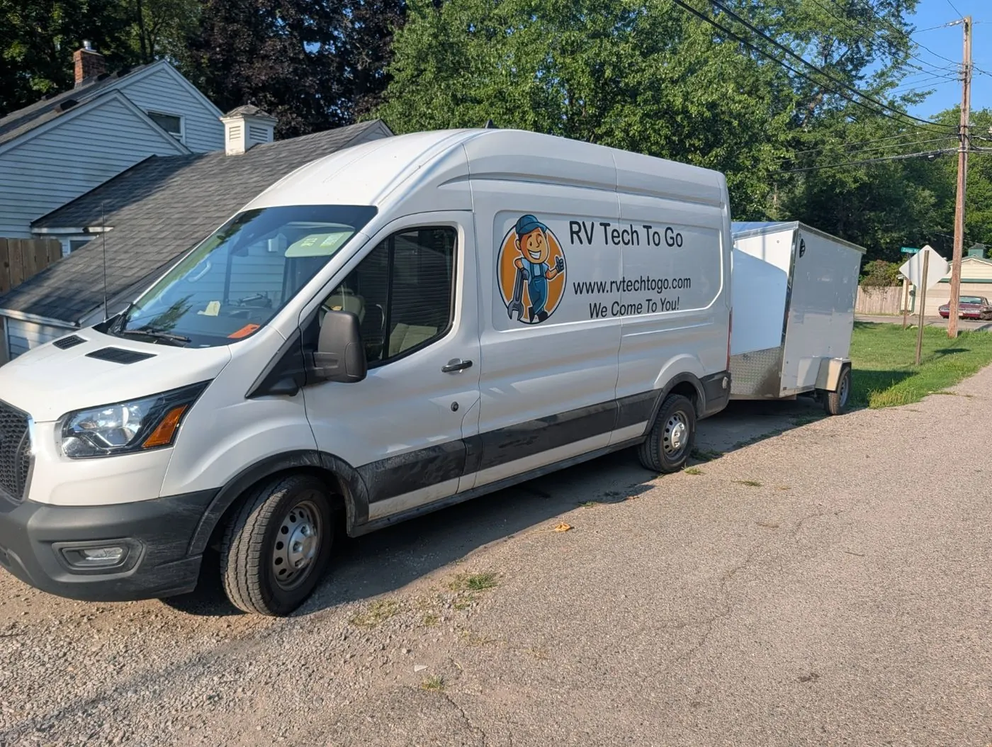 Branded RV Tech To Go Ford Transit work van towing the enclosed service trailer