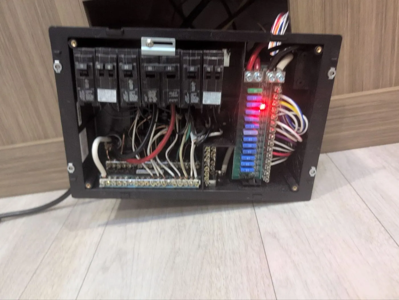 RV breaker and fuse distribution panel pulled from the wall with wiring exposed