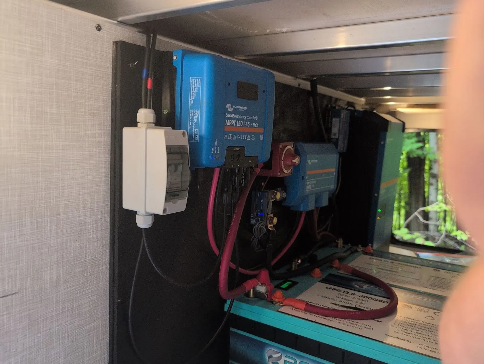 Victron SmartSolar MPPT charge controller mounted above a lithium battery in an RV compartment