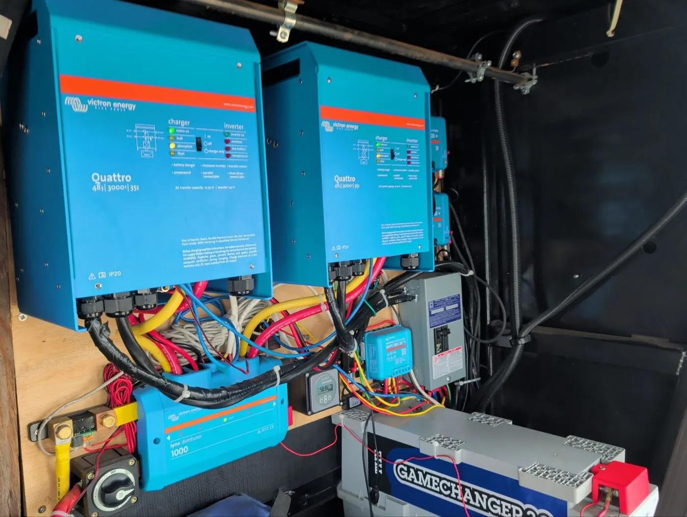 Two Victron Quattro inverter chargers mounted side by side above a lithium battery bank