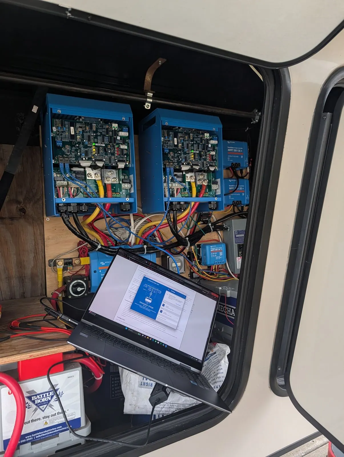Laptop connected to a pair of Victron MPPT charge controllers to configure and test the system after installation