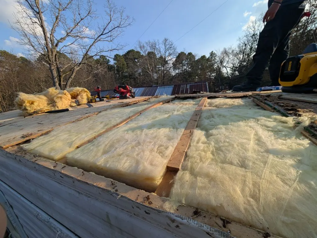 RV roof stripped to the rafters with new fiberglass insulation laid between them