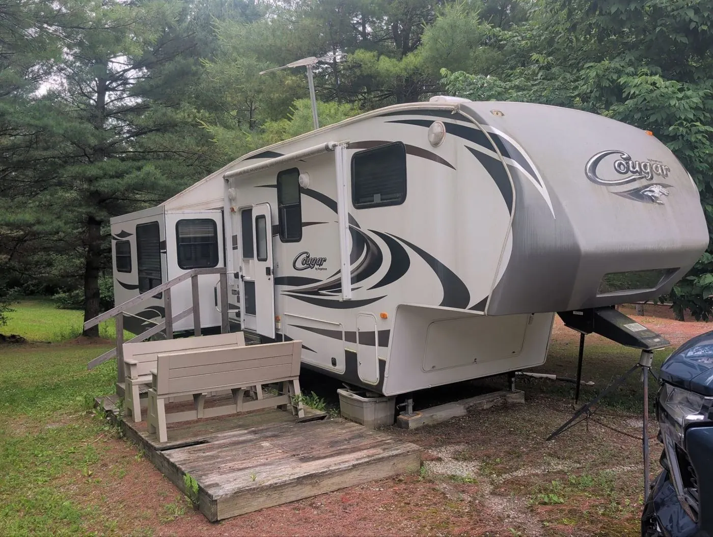 Fifth wheel set up on a seasonal campsite with a wooden deck