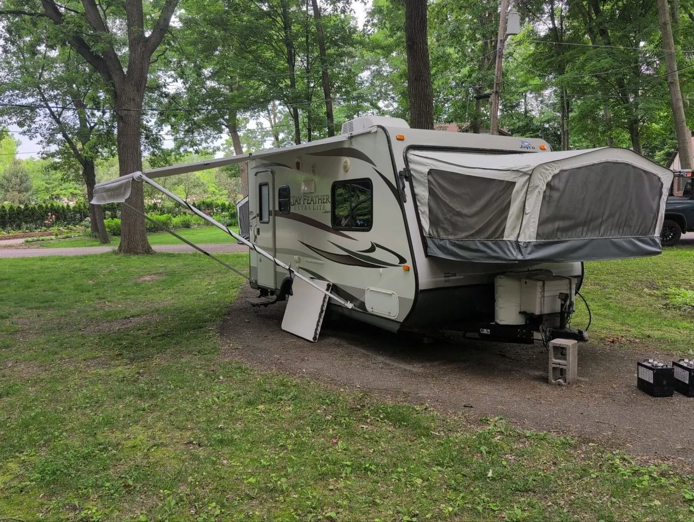 Expandable hybrid travel trailer with tent ends open at a campground