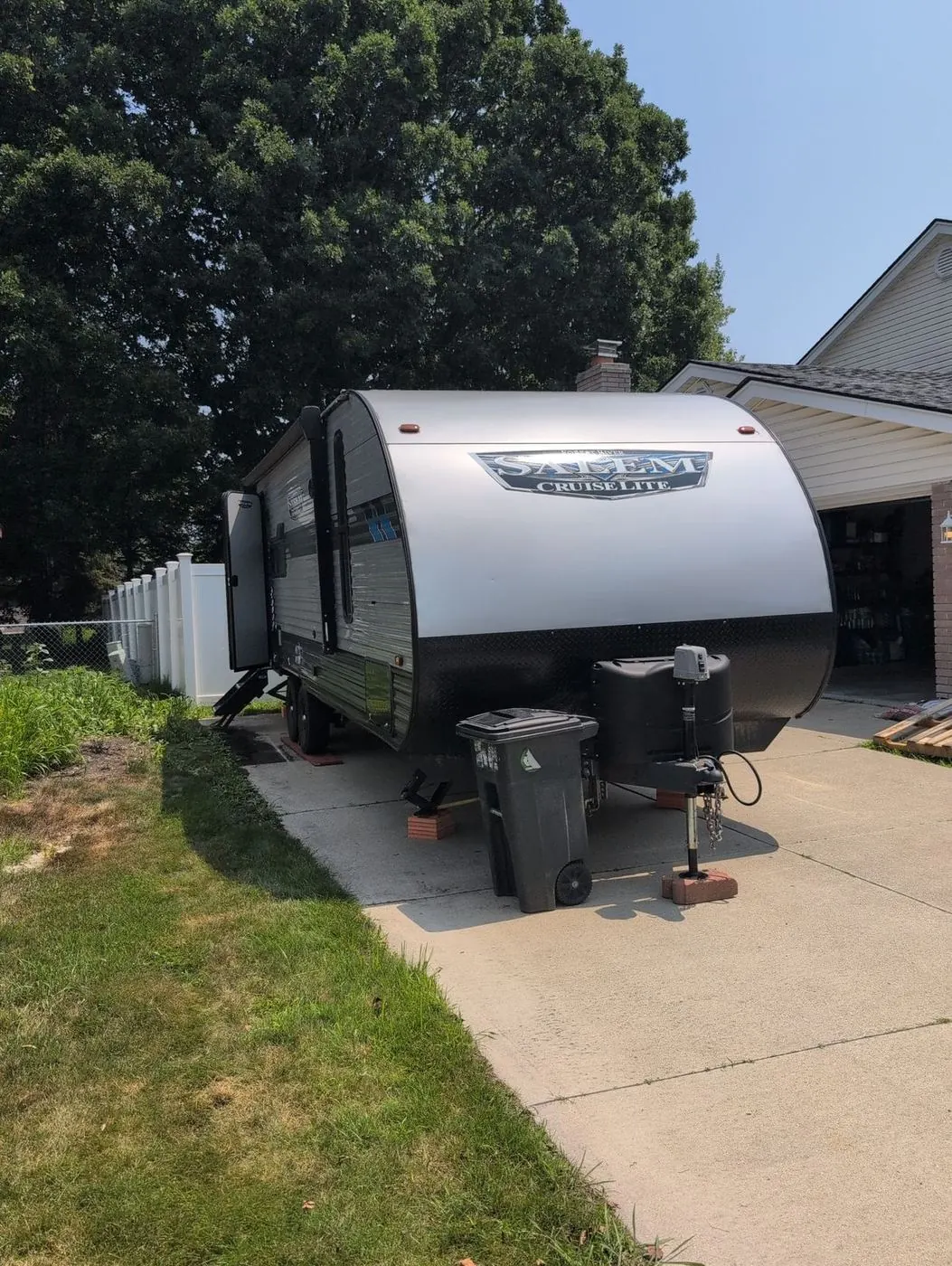 Travel trailer parked in a residential driveway for a service call